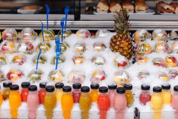 Fresh fruit cups and juices displayed on ice at a Barcelona market stall