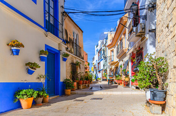 Fototapeta premium Alicante old town Barrio de Santa Cruz neighborhood with narrow street, typical white houses, traditional colorful buildings, Casco Antiguo Santa Cruz quarter in Alicante city historic centre, Spain