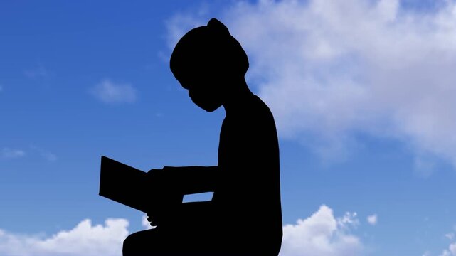 Silhouette of a Child Reading a Book Against a Blue Sky with Clouds for Education and Literacy Concept
