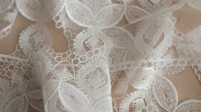 Luxury white Guipure lace fabric featuring intricate geometric and floral embroidery. High-quality bridal textile with raised textures and elegant raftsmanship, perfect for wedding fashion.