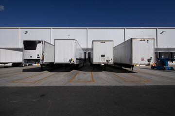 trucked trailers parked in front of distribution warehouse