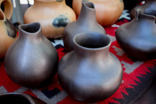 Handmade clay pottery vessels on patterned textile