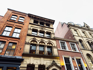 Naklejka premium Historic brick and stone city houses in Manchester showcasing architectural details and urban charm