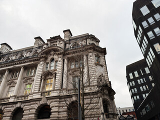 Naklejka premium Historic city hall style building in Manchester with modern high rise nearby in city center