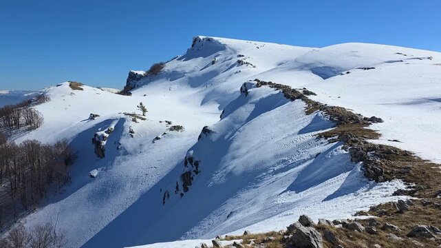 Spectacular snow cornice on the ridge of Monte Sirente massif, winter mountain landscape in Abruzzo, Italy