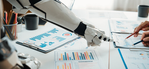 A robotic arm assists in analyzing business data, showcasing collaboration in a modern office....