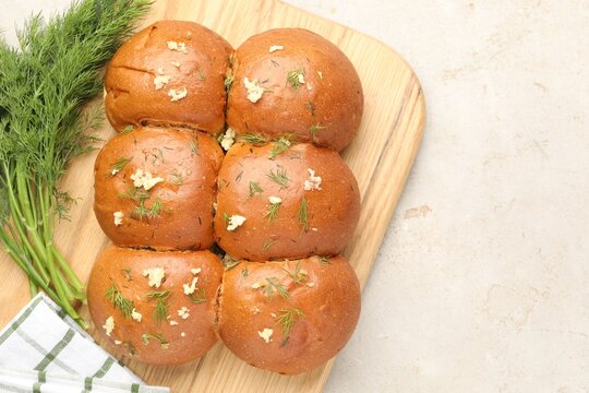 Fresh buns with garlic and dill on light table, flat lay