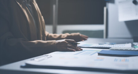 Business colleagues analyzing financial charts and reports on the table while having a focused...