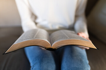 woman holding open bible while sitting at home, christian faith and daily devotional reading 