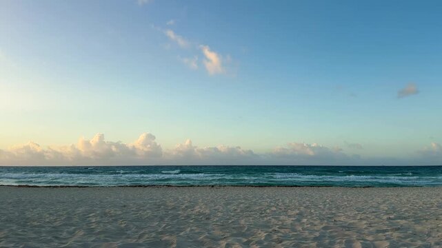 Calm Ocean Waves Rolling onto a Sandy Beach at Sunrise