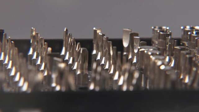 Close up of small screw driver and screw bolt bit set for a screwdriver on electronic electronics devices like boards, circuits, and repair jobs in slow motion and blurry defocused background plate