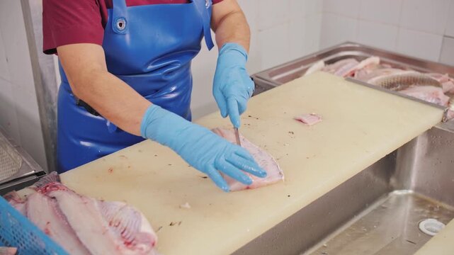Fishmonger Preparing Fish on a Cutting Board in a Seafood Market
