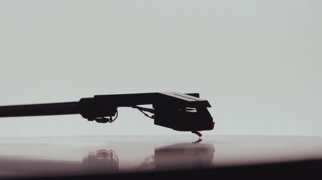 Vinyl record player needle stylus and tonearm playing music