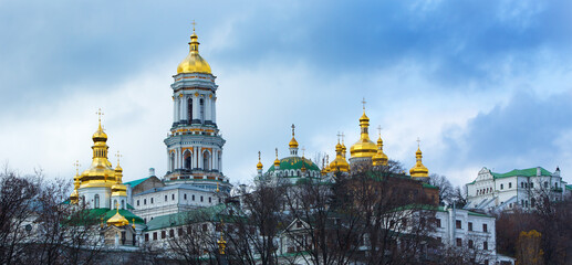 Obraz premium Scenic view of Kyiv, Ukraine featuring historic churches with golden domes shining under beautiful sunny weather. Colorful cityscape with remarkable architecture and religious landmarks symbolizing fa