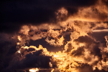 Fototapeta premium Dramatic Golden Sunset Sky with Dark Clouds