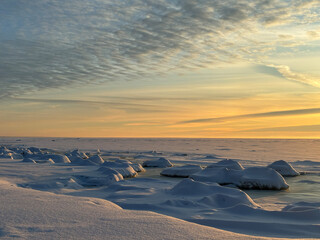 Frozen Sea Coast at Sunset with Snow Covered Ice and Dramatic Clouds © DaceSn