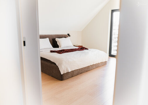 Modern Double Bed with White Linens in a Minimalist Attic Bedroom