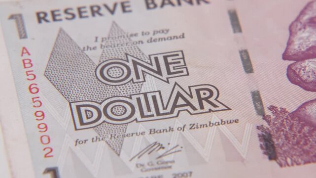 One dollar bill from African country reserve bank of Zimbabwe in South Africa close up slow motion of inflated foreign economy inflation with paper cash and rocks stacked on texture from 2024 prints
