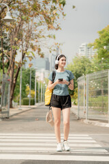 Fototapeta premium Young woman exercising regularly in public park, outdoor fitness routine with headphones and smartphone, healthy lifestyle and active urban wellness concept. exercise, park, routine, lifestyle