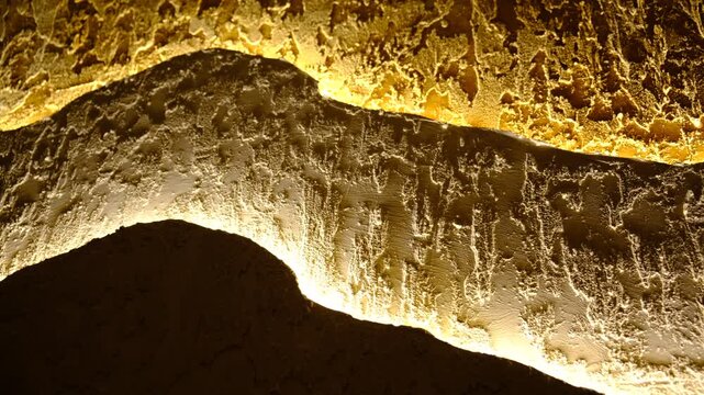 Modern apartment with three-layer wall , multilayer textured polymer mineral plaster, Abstract wavy curve  panel wall, installed with hidden glowing led, provides illumination for fashion interior