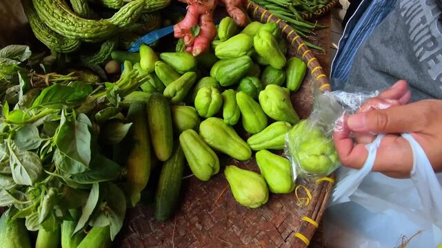 Video of a pile of small green chayote squash on a tray for sale at a traditional market. Footage of food sold at a traditional market in Indonesia. 4K HD Resolution