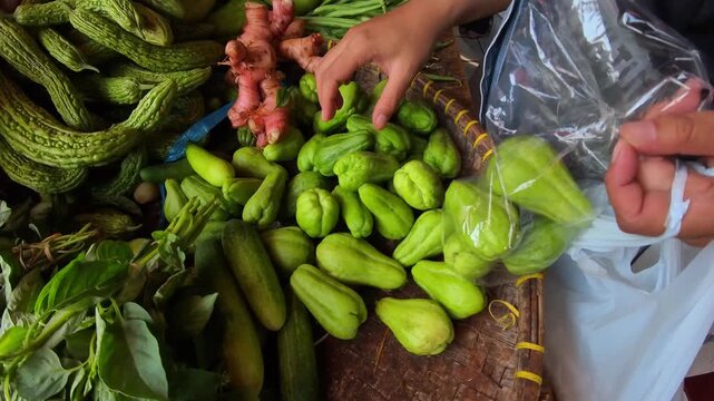Video of a pile of small green chayote squash on a tray for sale at a traditional market. Footage of food sold at a traditional market in Indonesia. 4K HD Resolution