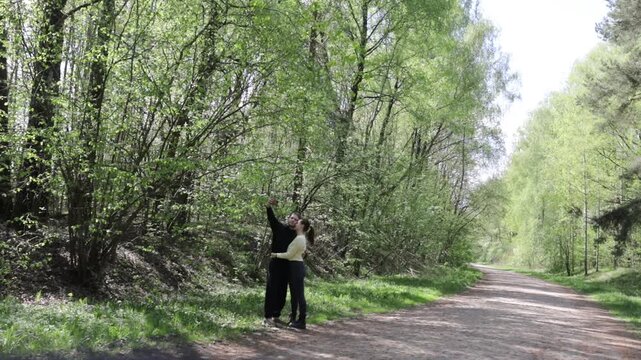 a young couple in love walking through a blooming spring park
