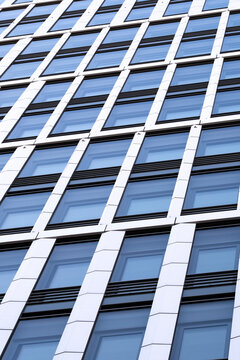 Modern glass building facade with windows in perspective showing abstract pattern and office architecture detail for clean contemporary corporate design