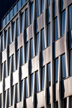 Abstract modern office building facade with windows in diagonal pattern showing geometry in architecture detail and clean minimal corporate exterior