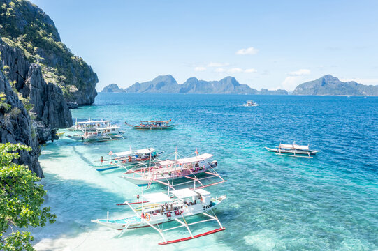 Aerial view traditional boats on turquoise water Seven Commandos Beach El Nido Palawan