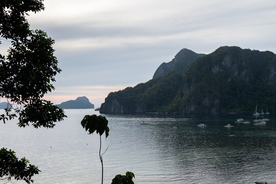 Sunset view of limestone cliffs over Corong Beach in El Nido with golden tropical sky