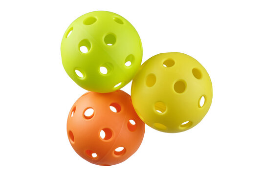 Three pickleball balls yellow orange and green isolated