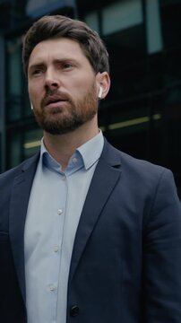Professional businessman Caucasian man leader in city talk phone earphones call guy male entrepreneur business coach developer real estate agent manager distant communication mobile downtown outdoors