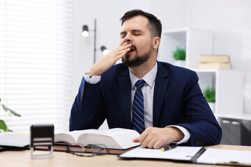 Man feeling fatigue at wooden desk in office