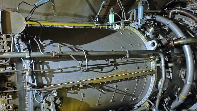 Closeup turbine core assembly with complex pipework and sensor fittings, metallic chambers and curved piping visible, technical overhaul scenario suggested, precision engineering atmosphere,