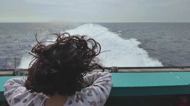 Little Girl with Curly Hair Watching Ferry Wake
