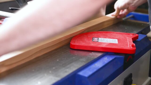 Carpenter operate electric jointer Planer remove excess wood with. Wood shaping, precision cut, workshop tool, material trim, professional skill, surface smoothing
