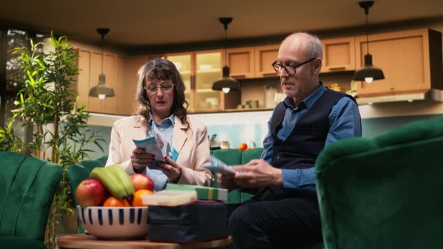 Retired couple reviewing flyer with healthcare information in living room. In-home elderly care and companionship to understand daily treatment and supplements, recovery for old age.