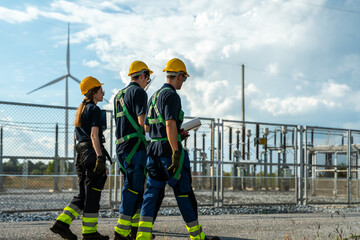 Electrical engineering team conducting walkdown at high-voltage substation facility. Specialists inspecting power grid transmission infrastructure and utility network.