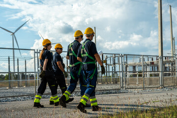 Electrical engineering team conducting walkdown at high-voltage substation facility. Specialists inspecting power grid transmission infrastructure and utility network.