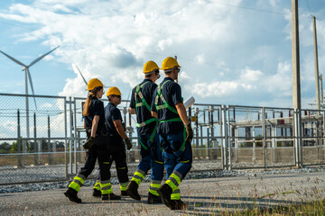 Electrical engineering team conducting technical walkdown at high-voltage substation facility. Specialists inspecting power grid transmission infrastructure and utility network.