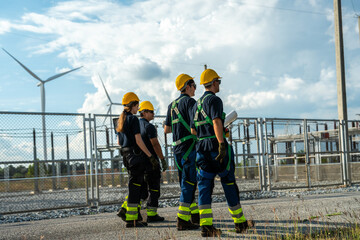 Electrical engineering team conducting walkdown at high-voltage substation facility. Specialists inspecting power grid transmission infrastructure and utility network.