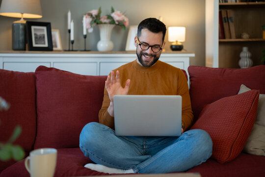 Man waving during online video call from home
