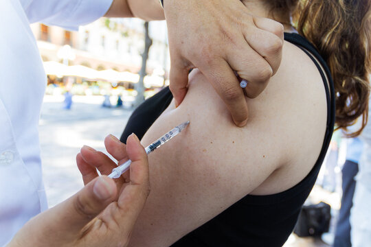 Measles vaccine administration in Mexico health campaign. Healthcare worker injecting a vaccine dose into a patient's arm