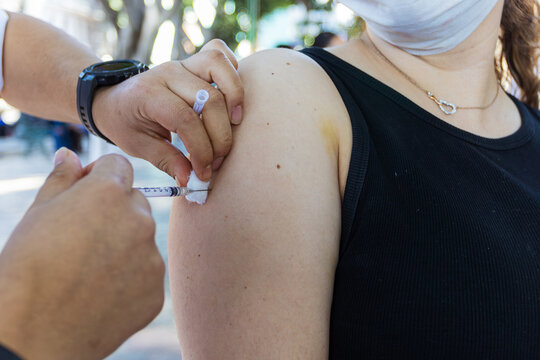 Measles vaccine administration in Mexico health campaign. Healthcare worker injecting a vaccine dose into a patient's arm