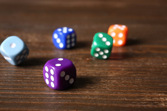 Colorful game dices on wooden background, closeup