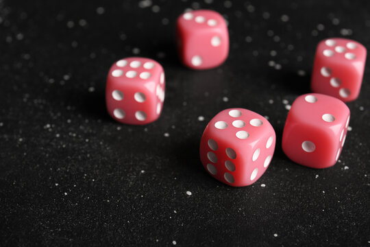 Pink dices on dark background