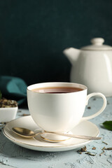 Cup of tasty black tea on blue grunge background, closeup