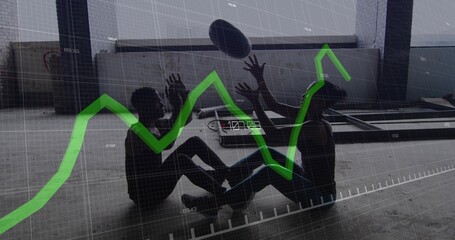 Naklejka premium Reaching two adults in gym clothes stretching for oval ball in warehouse with green graph overlay