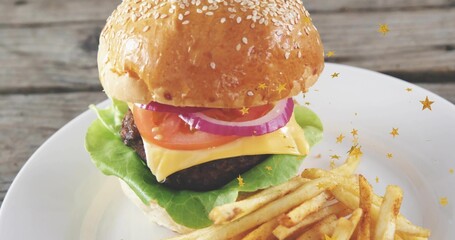 Naklejka premium Displaying stacked burger with sesame bun, cheddar and fries on ceramic plate, gold stars